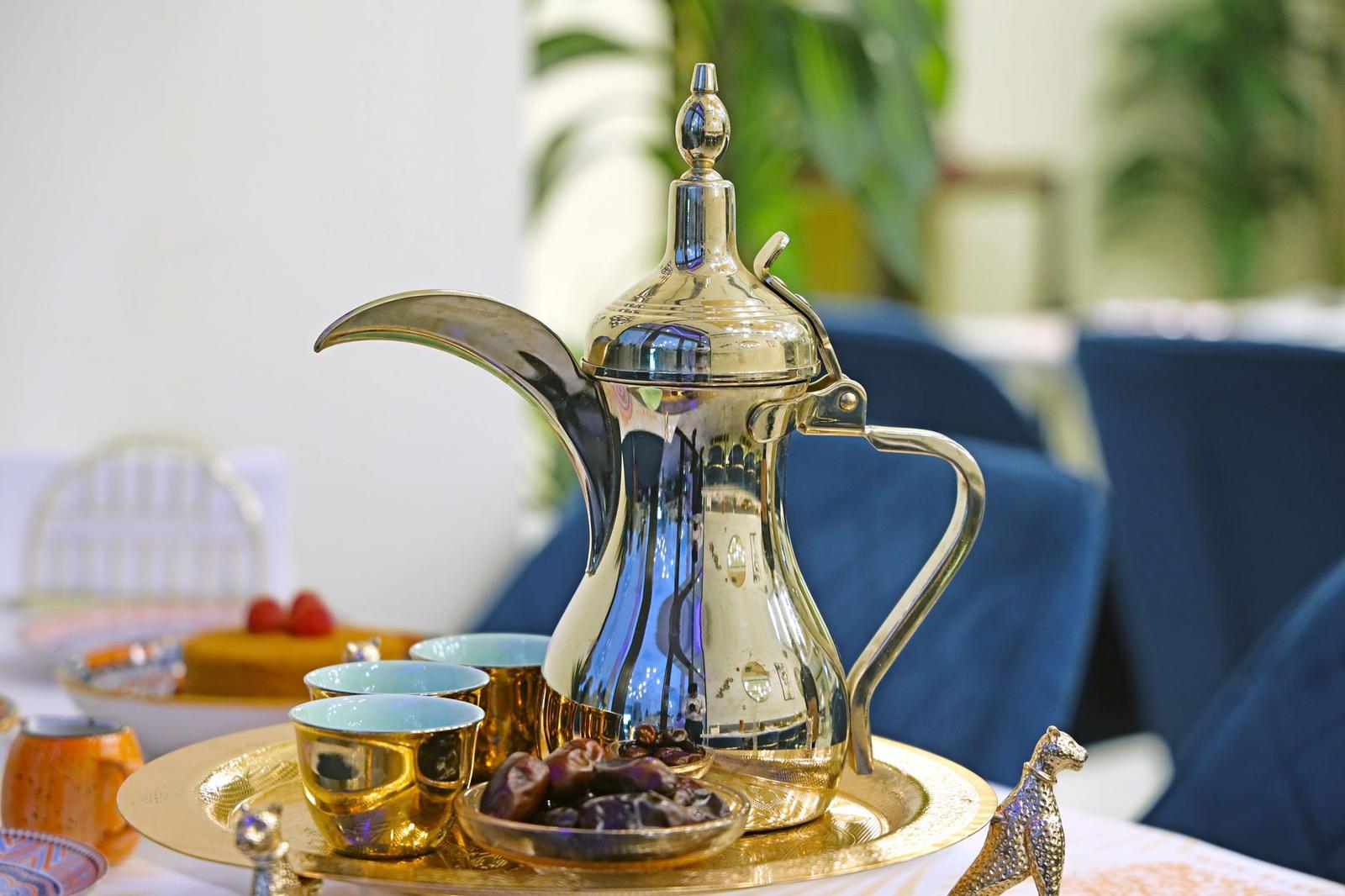 A Silver Tea Pot Sits on a Tray with a Plate of Food